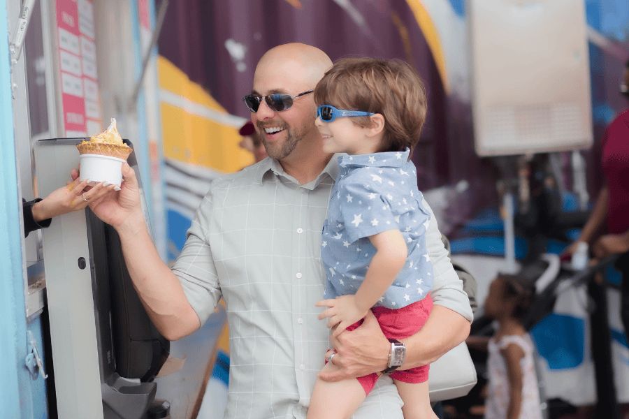 A father buying ice cream for his son at part Orlando, Florida